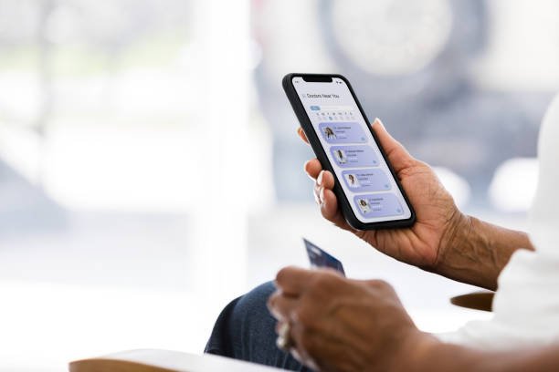 Unrecognizable senior woman using a credit card to pay for an online telemedicine appointment on her laptop.