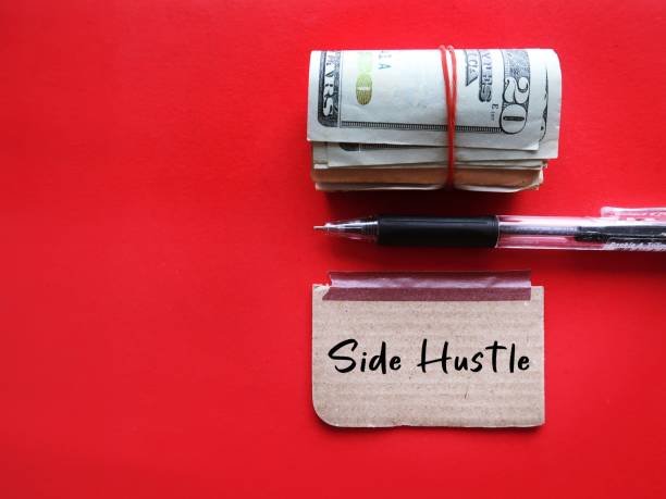 Cash, dollar bills, and a pen placed on a sticky note with the words “SIDE HUSTLE,” symbolizing extra income from online businesses, side gigs, or second jobs.