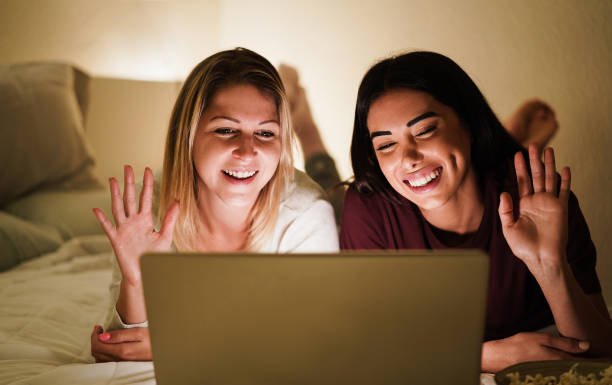girls having video call at home using laptop computer during lockdown isolation